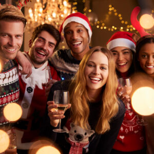people dressed in holiday festive clothes holding wines